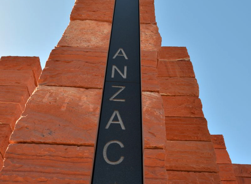 The word ANZAC inscribed on black marble in the centre of a red pillar